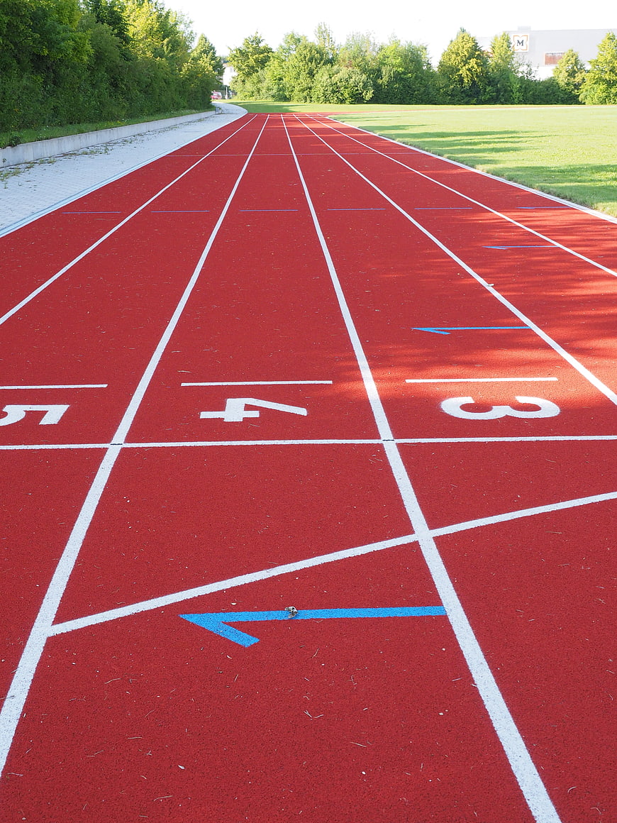 Red Tartan Running Track With White Lane Lines And Numbers