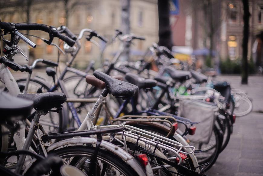Row of parked bicycles on a rainy city street