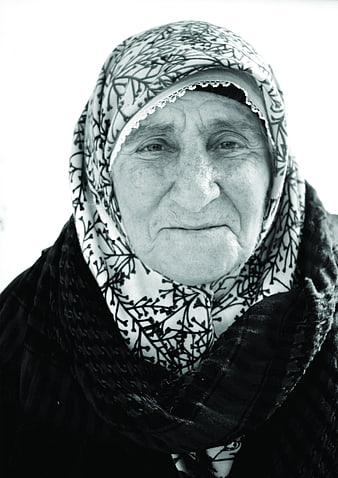 Black and white portrait of elderly woman in headscarf