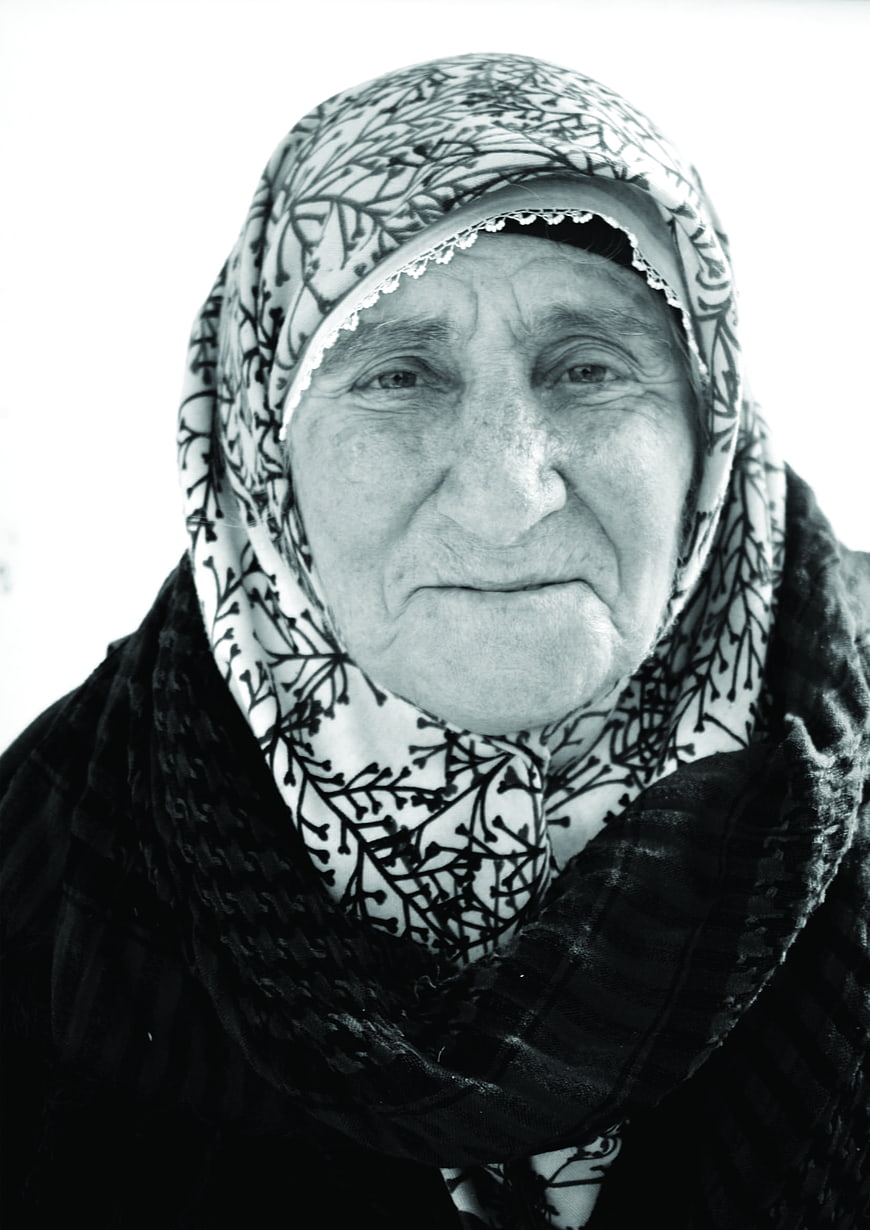 Black and white portrait of elderly woman in headscarf