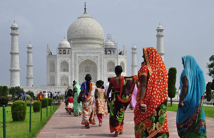 Women in colorful saris walking toward the Taj Mahal in Agra, India