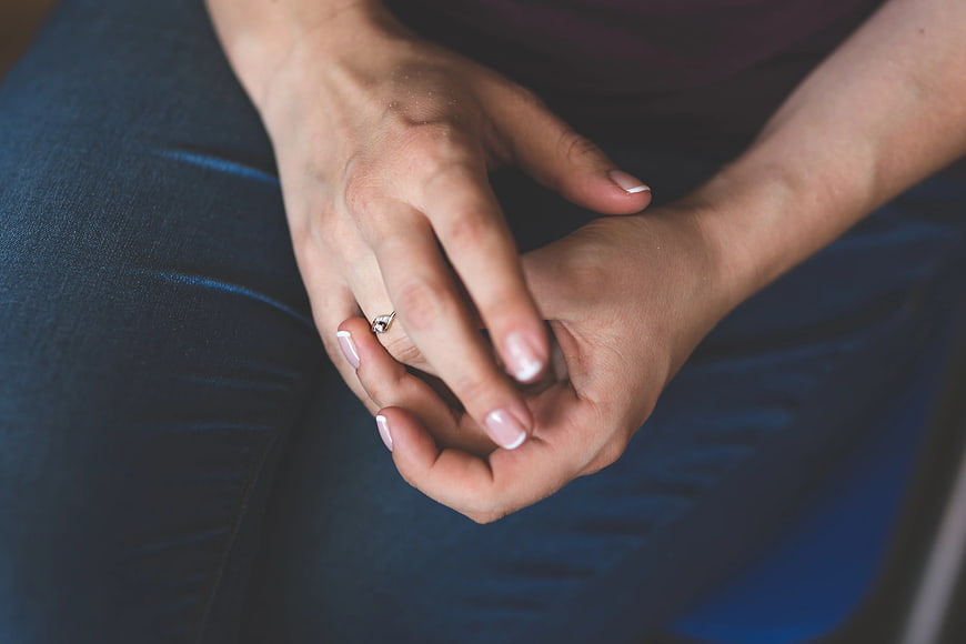 Close-up of woman's hands with diamond engagement ring