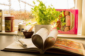 Open Cookbook with Heart Shape and Fresh Herbs on Kitchen Counter