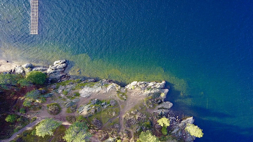 Aerial View of Rocky Coastline with Clear Blue Water