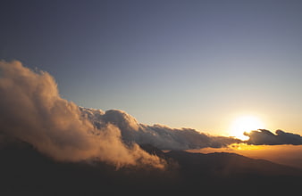 Dramatic sunset over mountain peaks with clouds