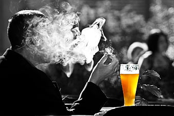 Man smoking cigarette with glass of beer in selective color