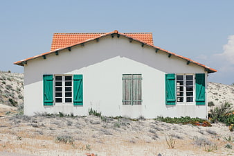 White House with Green Shutters in Sandy Landscape