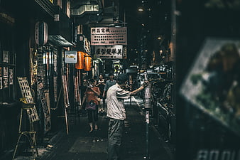 Night street scene in Asian city with pedestrians and shops