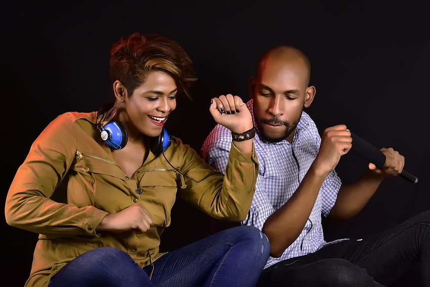 African American couple dancing and listening to music with headphones