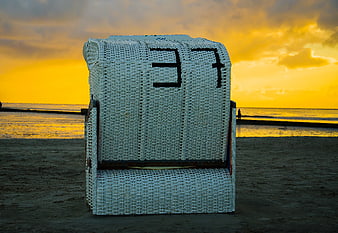 White Wicker Beach Chair at Golden Sunset
