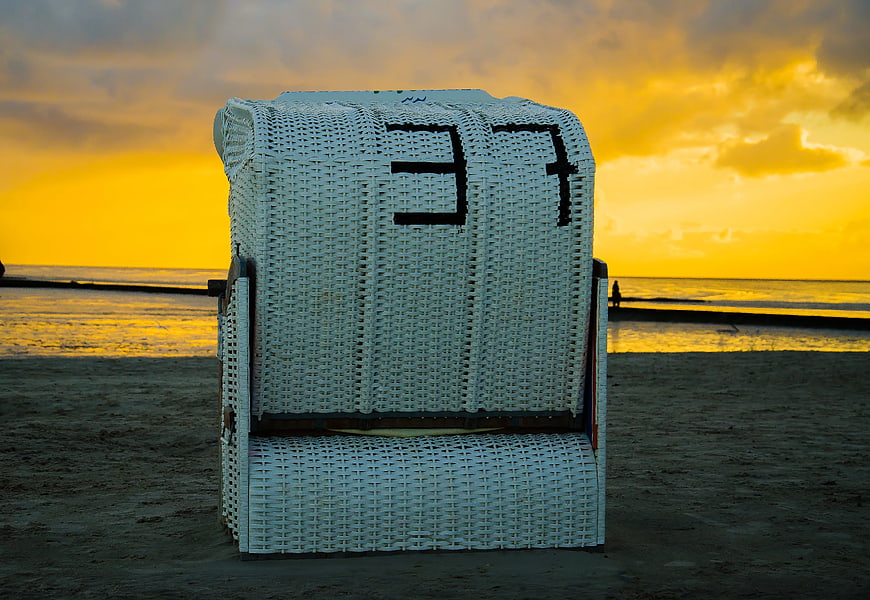 White Wicker Beach Chair at Golden Sunset