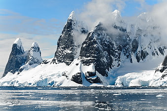Dramatic Snow-Covered Mountains Rising from Icy Antarctic Waters
