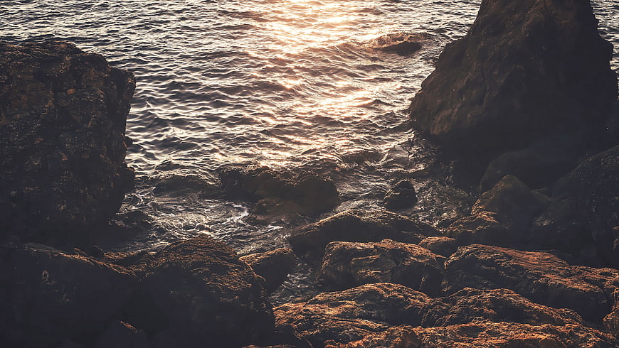 Sunset Reflection on Rocky Ocean Coastline