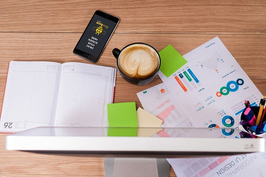 Flat lay workspace with coffee, charts, and smartphone