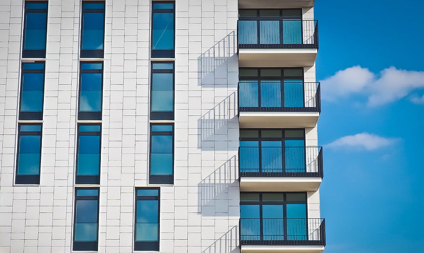 Modern White Apartment Building Facade with Blue Sky