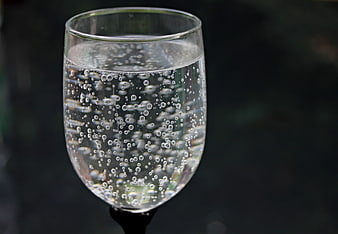 Close-up of a glass of sparkling water with rising bubbles