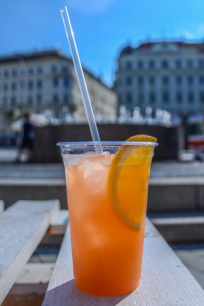 Refreshing Orange Cocktail with Straw on Wooden Table