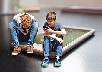 Two Boys Sitting On Giant Smartphone Concept