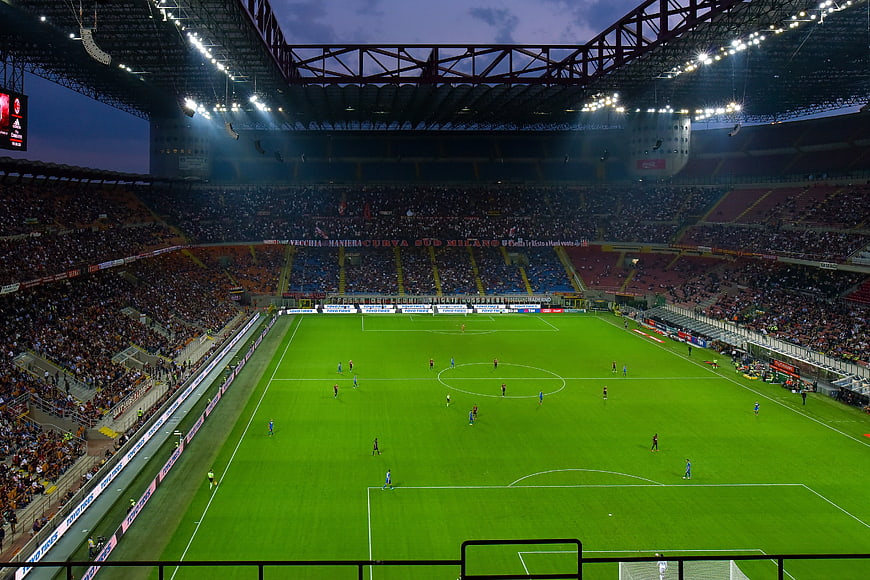 Wide view of San Siro stadium during a football match at dusk