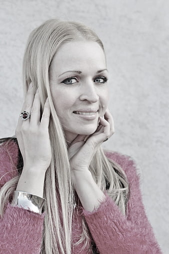 Portrait of smiling blonde woman in pink sweater