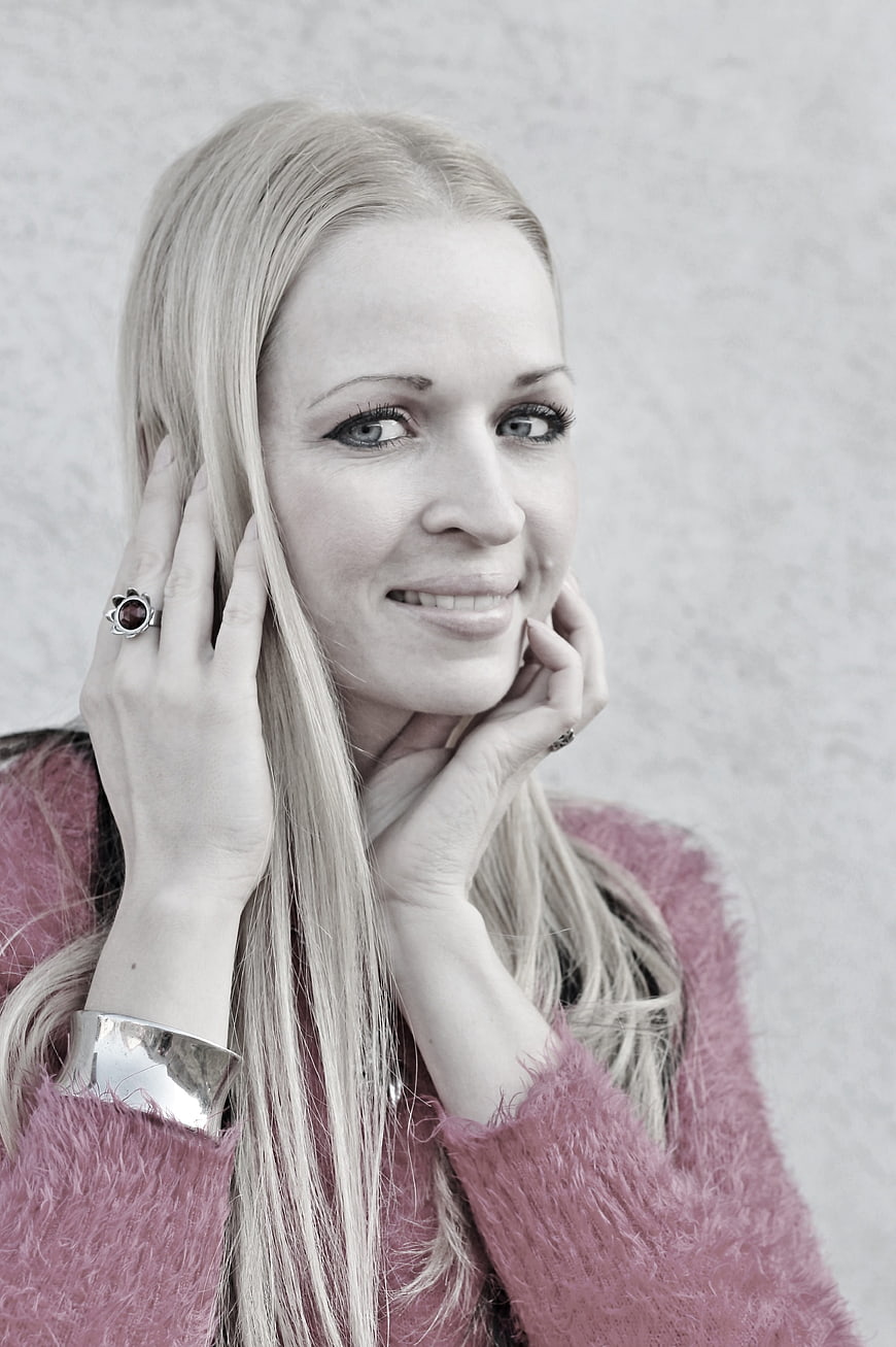 Portrait of smiling blonde woman in pink sweater
