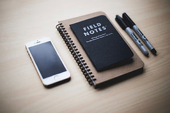 Minimalist Workspace with Smartphone, Notebook, and Pens
