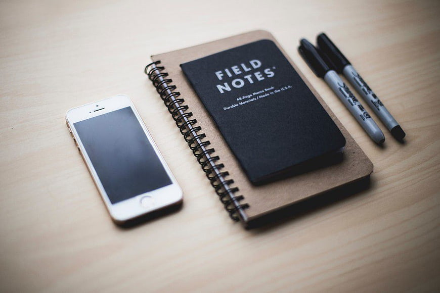 Minimalist Workspace with Smartphone, Notebook, and Pens