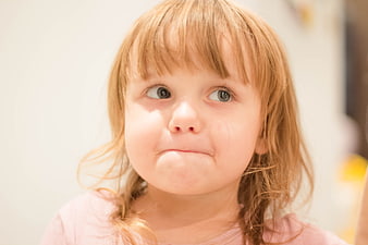 Cute toddler girl with pouty expression looking sideways