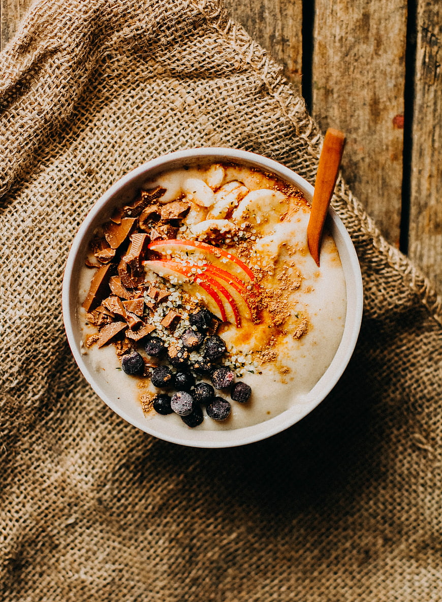 Overhead view of oatmeal bowl with fruit and toppings