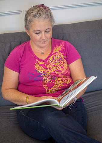 Woman Reading Book on Gray Sofa