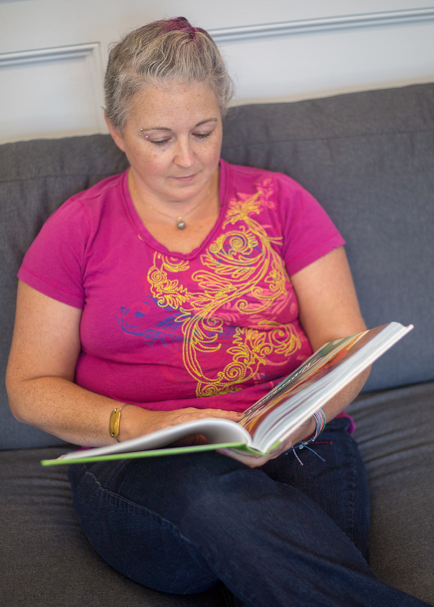 Woman Reading Book on Gray Sofa
