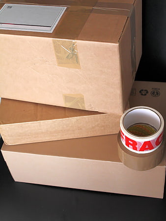 Stacked cardboard shipping boxes with packing tape on dark background
