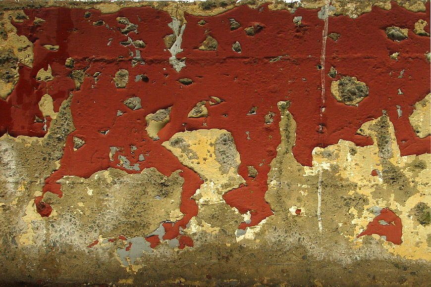 Grunge red peeling paint texture on old concrete wall