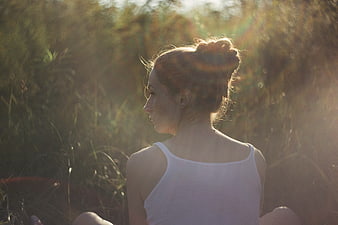 Woman meditating in golden sunlight outdoors