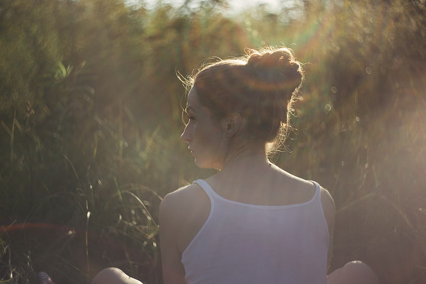 Woman meditating in golden sunlight outdoors