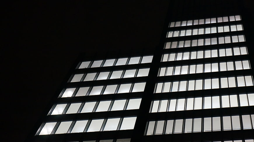 Low angle view of illuminated office building windows at night