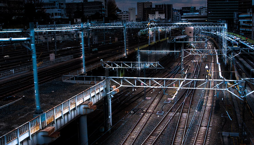 Urban Railway Tracks at Dusk with Overhead Catenary System