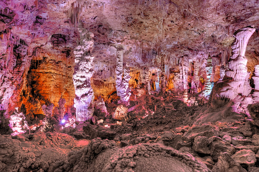 Colorful illuminated stalactites and stalagmites in a limestone cave