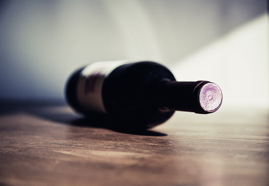 Close-up of wine bottle lying on wooden table