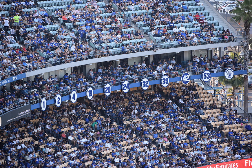 Crowd in blue seats at a baseball stadium during a game