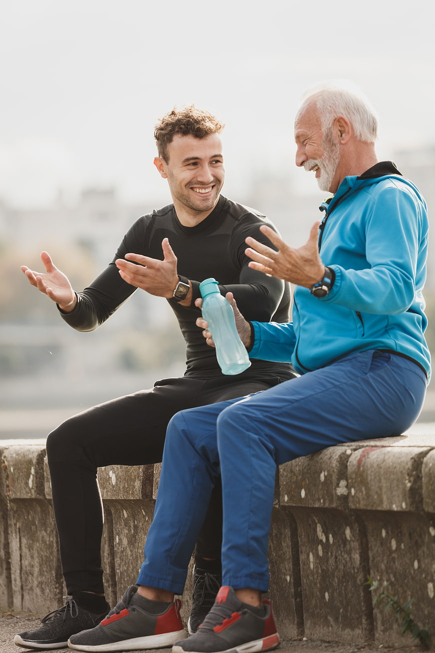 Senior and young man laughing after outdoor workout