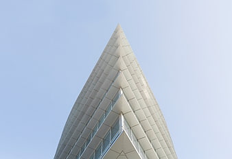 Modern triangular skyscraper architecture against blue sky