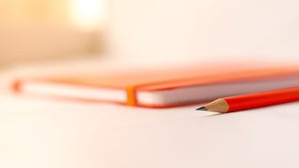 Red Pencil And Notebook On White Desk