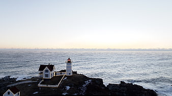 Aerial View of Lighthouse on Rocky Coast at Dusk