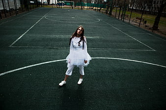 Woman in White Dress on Empty Basketball Court