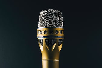 Close-up of a gold microphone on a dark background
