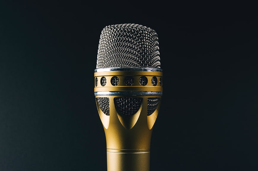 Close-up of a gold microphone on a dark background