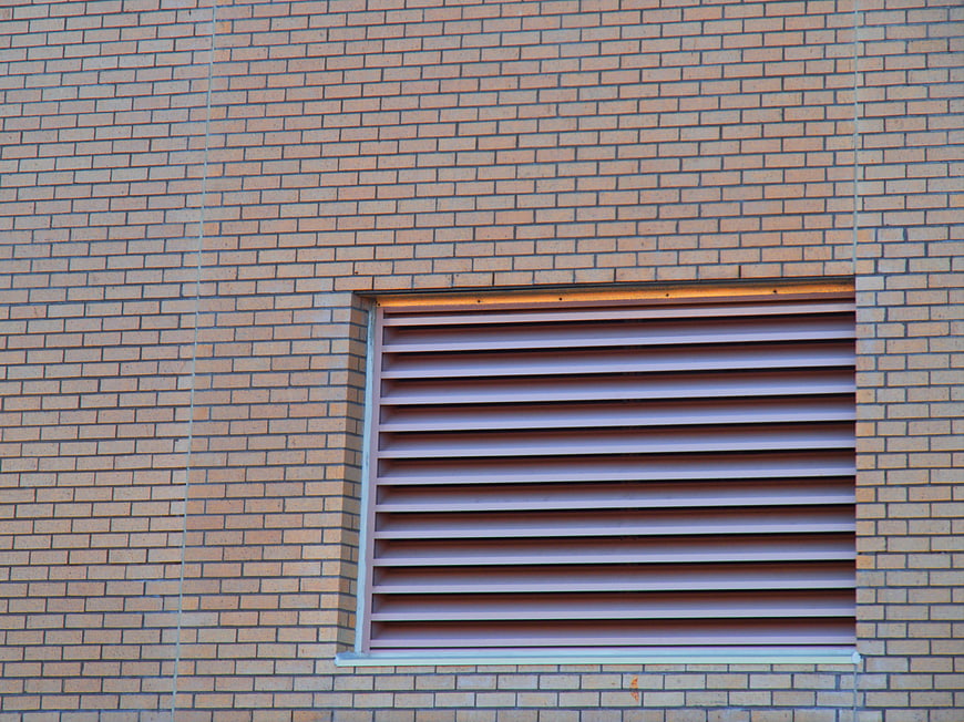 Abstract brick wall texture with horizontal ventilation louvers