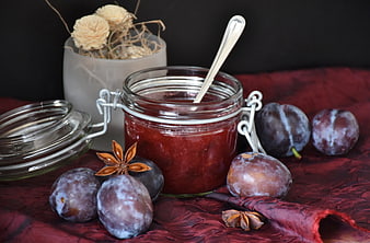 Homemade plum jam in glass jar with fresh plums and star anise