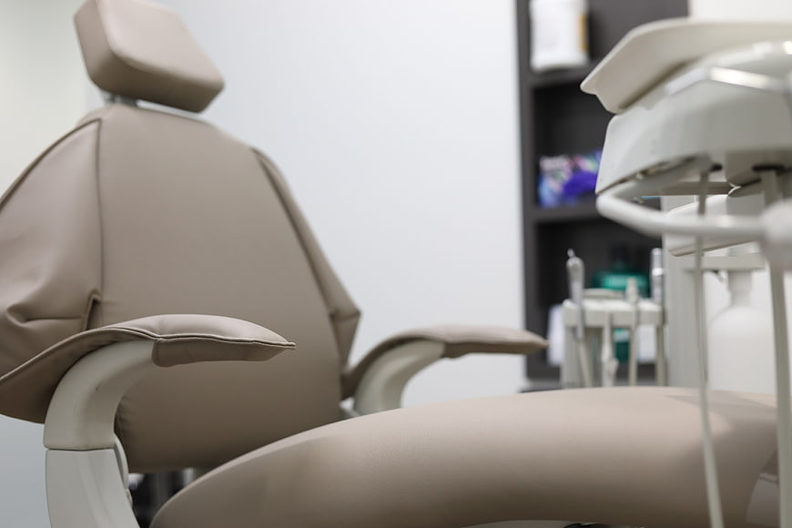 Empty beige dental chair in modern clinic interior